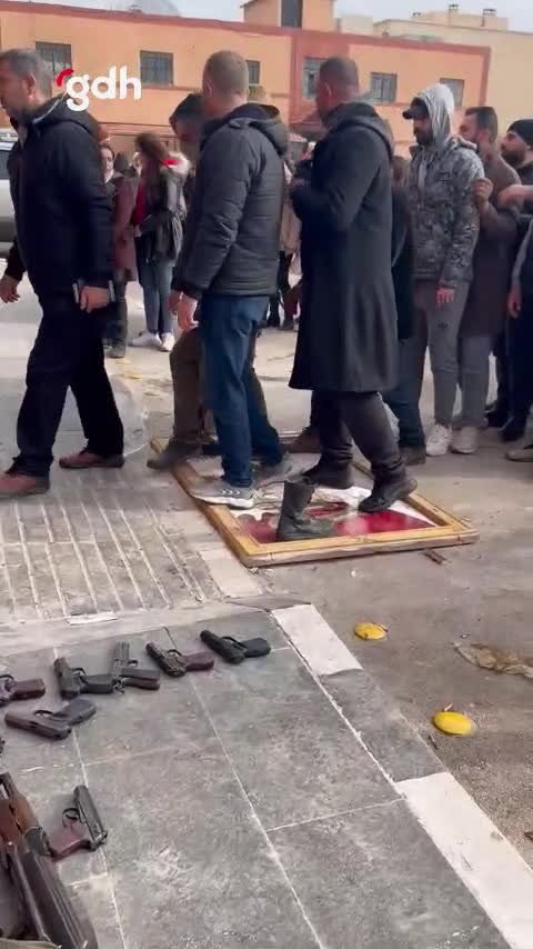 Askerler, Esad resimlerine basarak silahlarını teslim ediyor